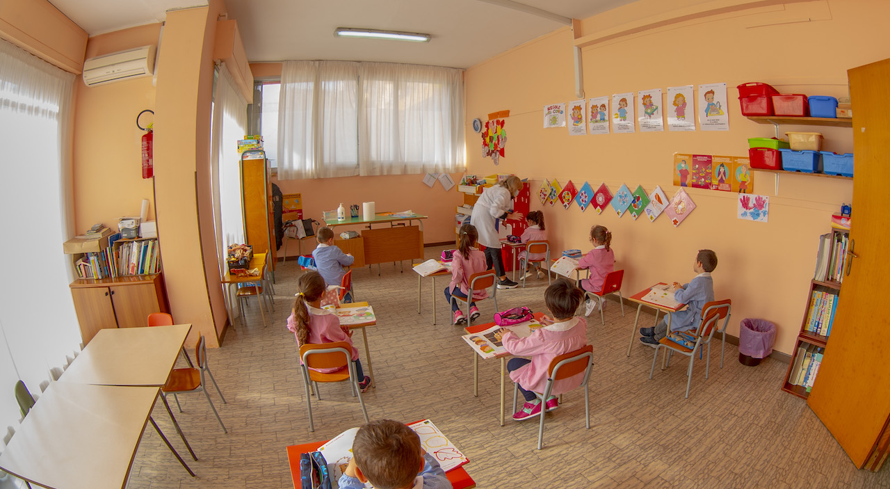 Bambini svolgono attività in sezione con la guida della loro maestra 